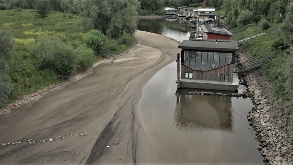 Het water in de rivieren staat 15 juli 2022 zo laag dat woonboten al scheef gaan staan. Foto: Omroep Gelderland