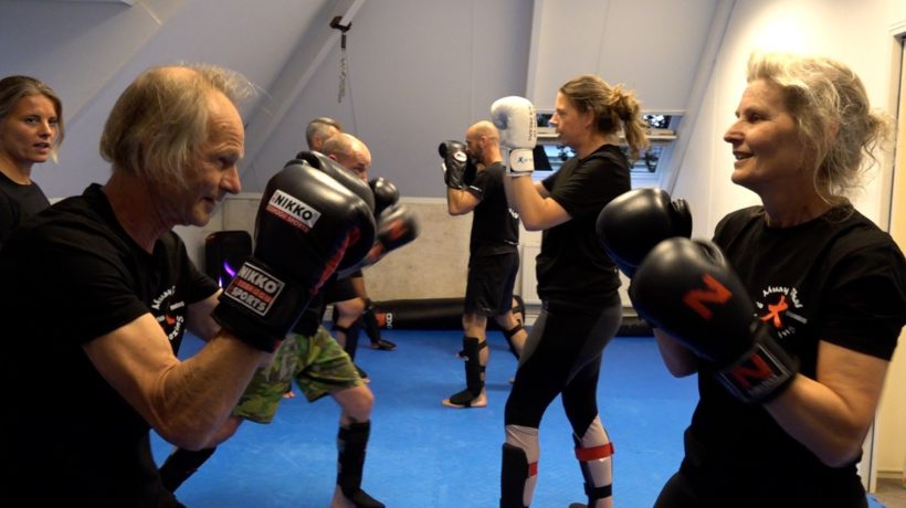 Nico (71) en Renske (62) sparren met elkaar. Trainster Krista Fleming kijkt achter hen toe. Foto: Omroep Gelderland