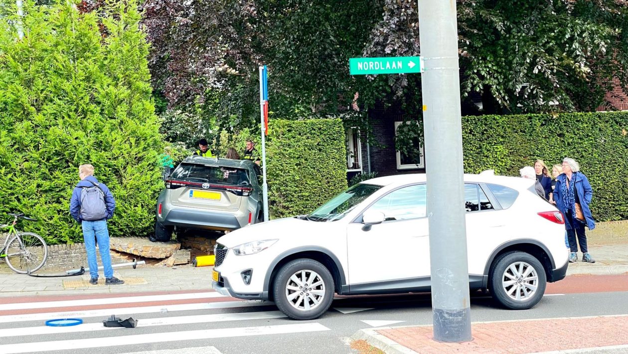 Auto rijdt door stenen muur de tuin in Foto: Martin Slijper