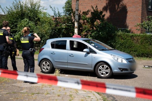 Een agent maakt foto's van een auto binnen de afzetting. Foto: Persbureau Heitink