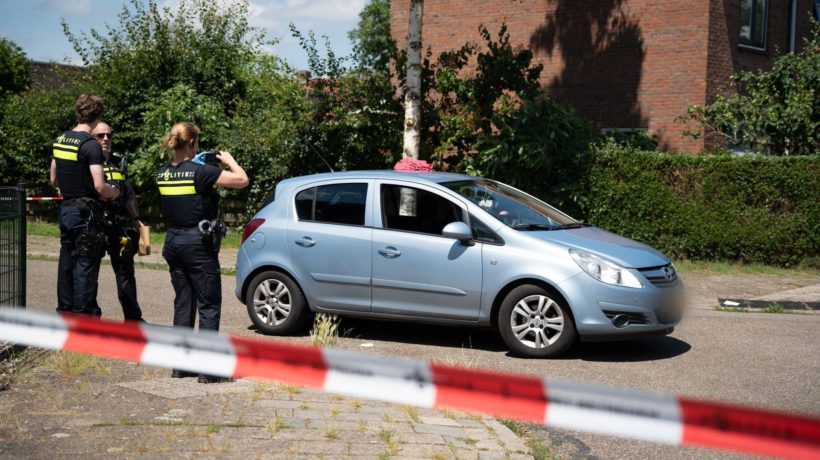 Een agent maakt foto's van een auto binnen de afzetting. Foto: Persbureau Heitink